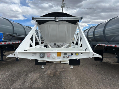 Ranco Versa dump trailer hitch rear view showing white frame and hopper with black tarp cover and mounting hardware.