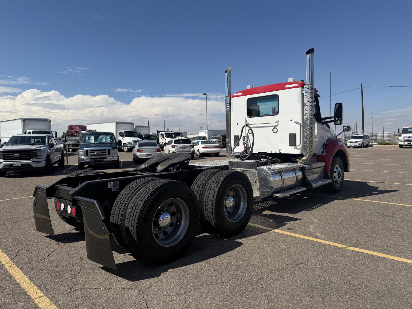 Kenworth T880 conventional daycab tractor rear/side view showing dual rear axles and exhaust stacks.