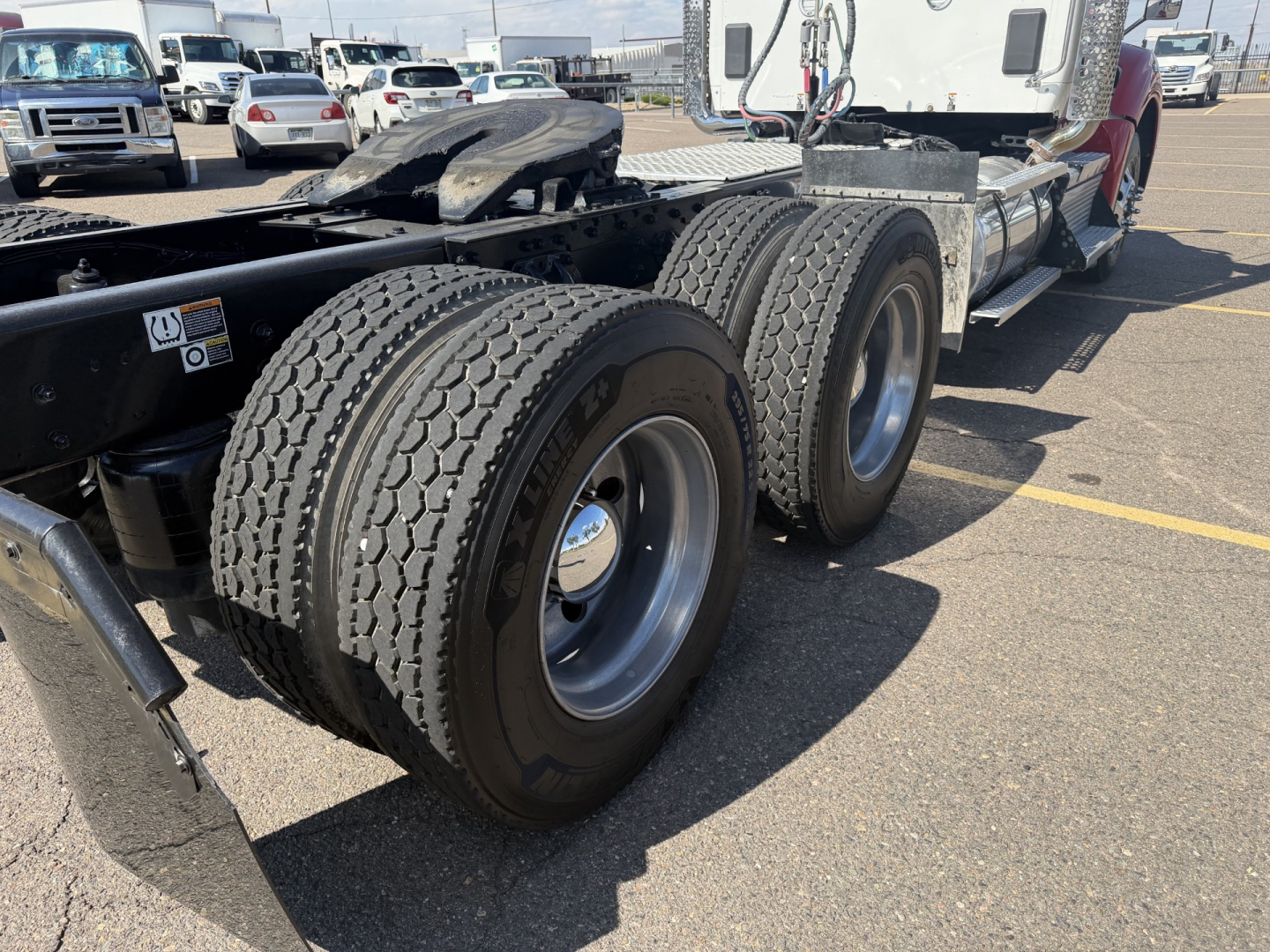 Kenworth T880 chassis with dual rear axles and dual tires in view; metal fuel/aluminum fuel tank and fifth wheel visible.