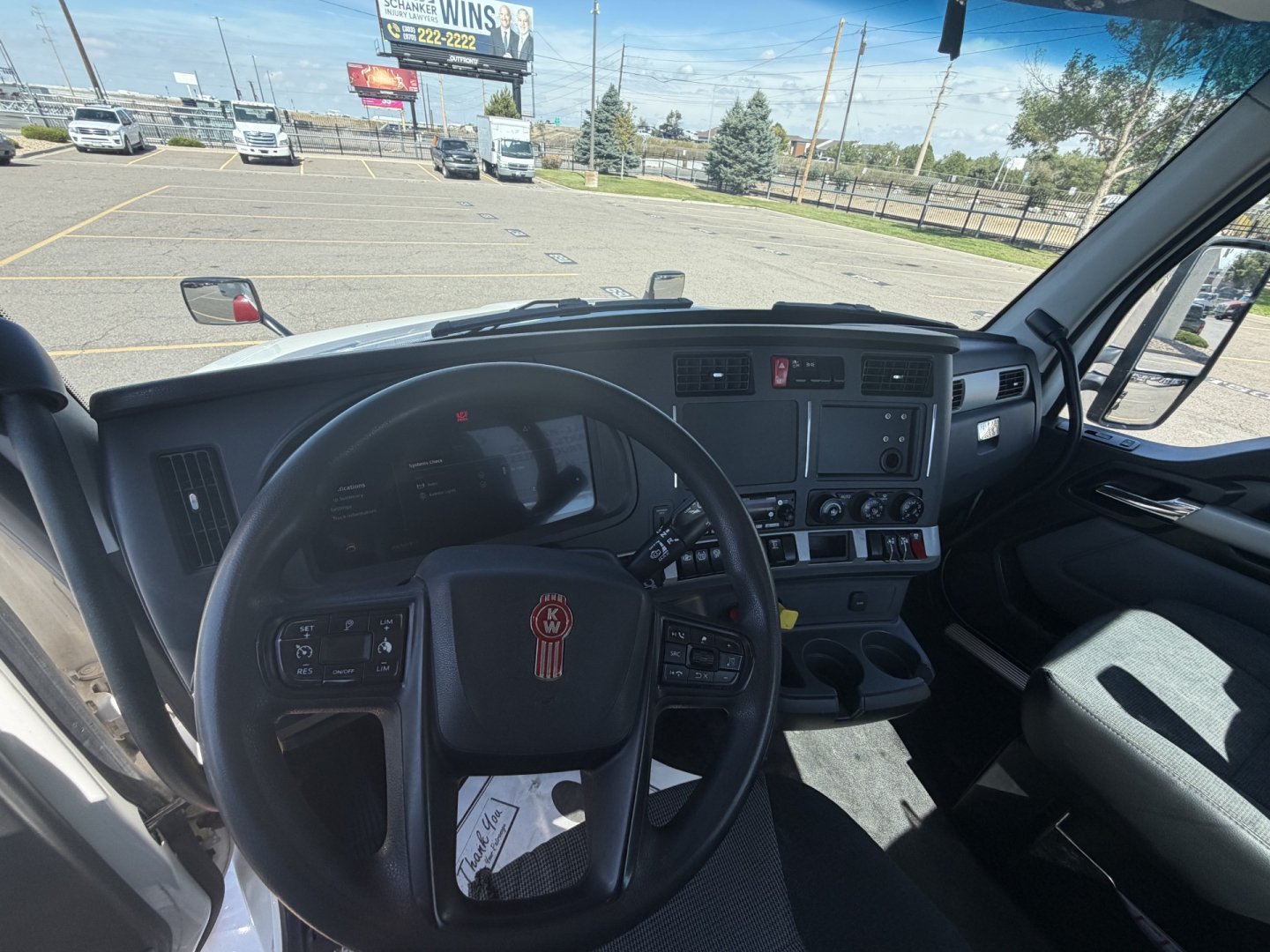 Kenworth T880 truck interior dash and steering wheel view from driver seat with dashboard controls and center console visible.