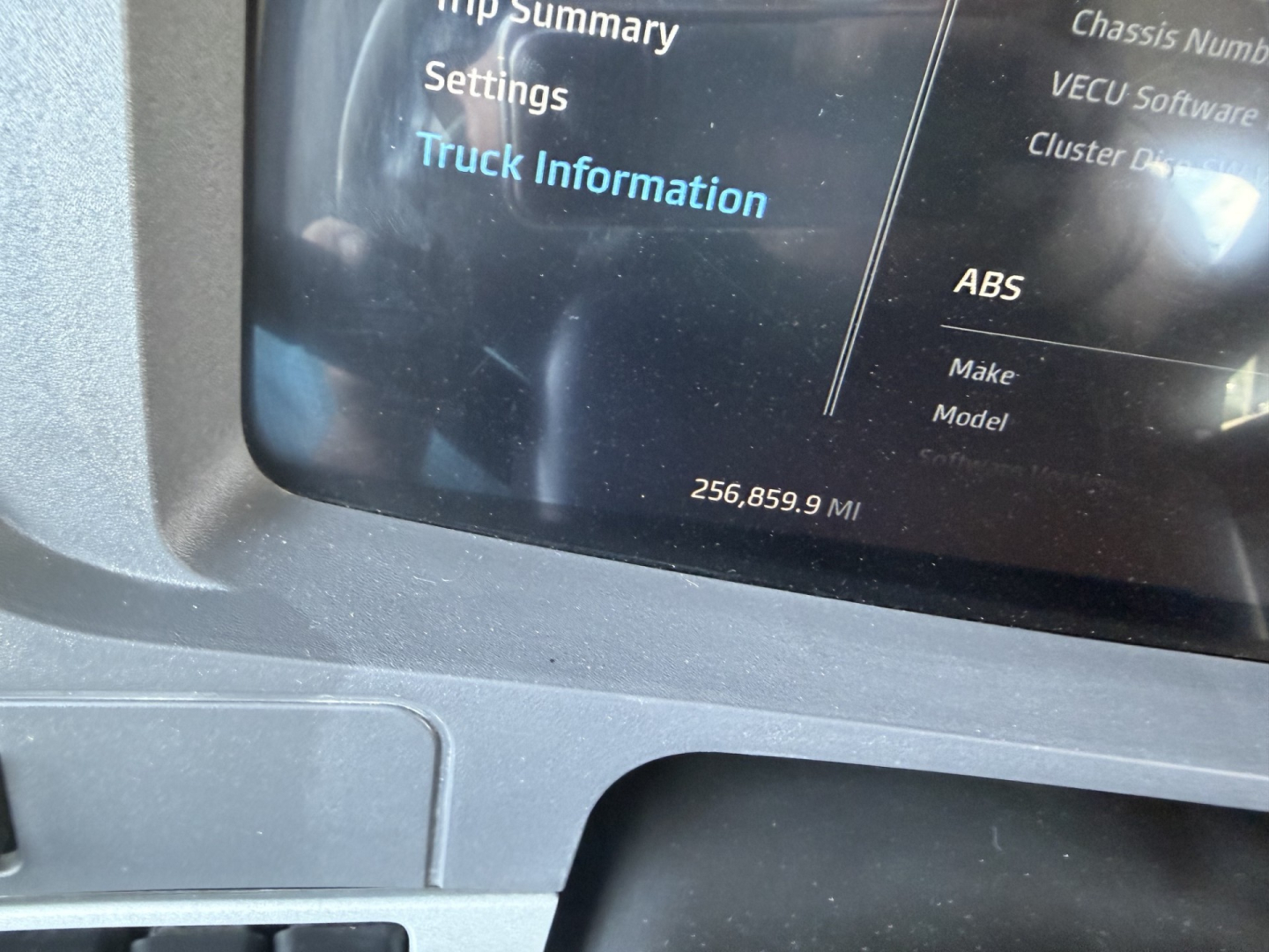 Kenworth T880 truck information screen showing 256,859.9 miles and ABS text on display.