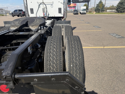 Kenworth T880 chassis showing twin rear dual tires and frame with components in the foreground, view from side of tractor.