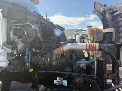 Kenworth T880 engine bay view showing intake hoses, coolant reservoir, and intercooler piping in the front, 2023 model year truck
