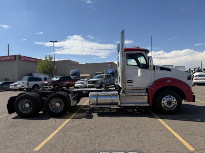 Kenworth T880 conventional daycab truck side view showing chassis with dual rear axles, fuel tank, and chrome sleeper exhaust stack.