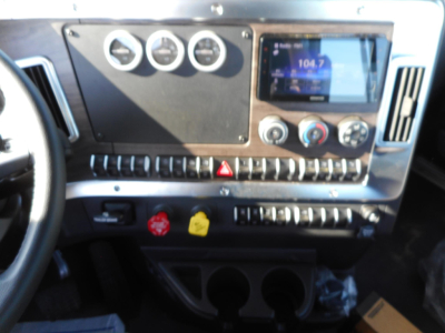Dashboard interior of a 2026 Western Star 49X showing gauge cluster, touchscreen display, and row of control switches.