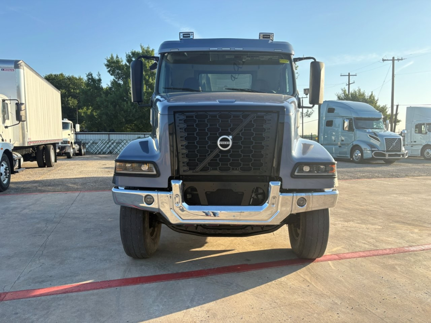 Front view of a Volvo dump truck showing large black grille, Volvo emblem, chrome bumper, and dual headlights.