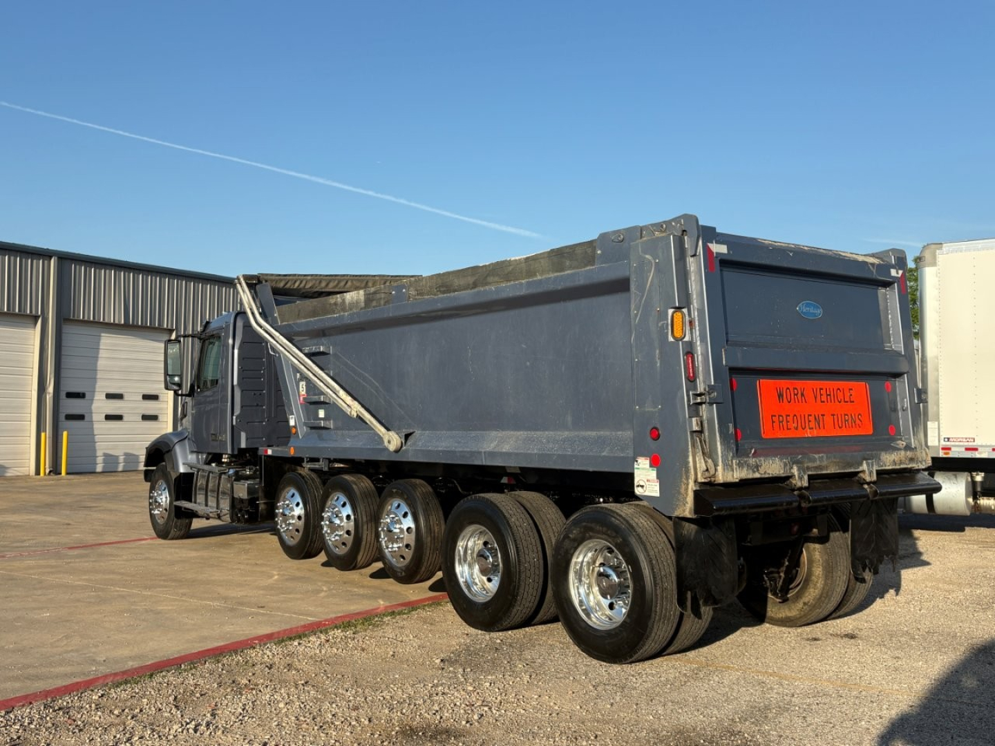 Volvo VHD104F300 dump truck in-service showing rear and multiple axles with large metal dump bed.