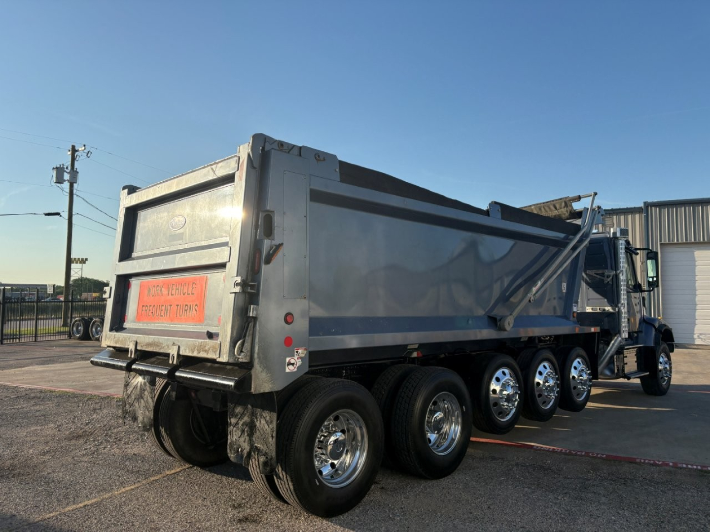 Dump truck showing rear and side of Volvo VHD platform with multiple rear axles and dump bed.