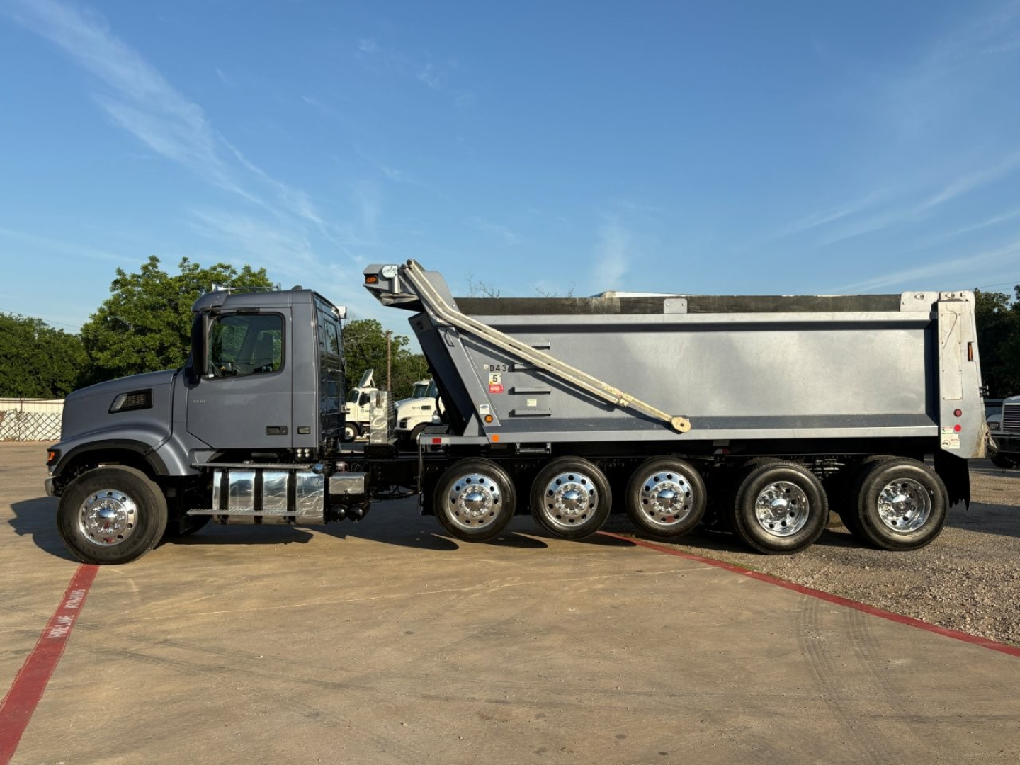 Volvo VHD104F300 dump truck side view showing dump body, multiple axles, and hydraulic lift system.