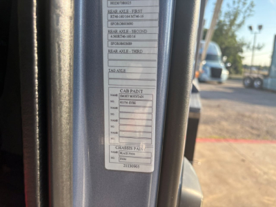 Cab label showing axle weights and paint codes on Volvo truck door jamb. Visible lines include rear axle first, second, third weights and cab paint and chassis paint fields.