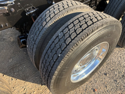 Dual rear wheels with treaded tires and polished chrome rims on a Volvo VHD truck chassis. Visible suspension components and wheel assembly.