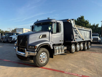Volvo VHD dump truck in-side view showing large front grille, dual mirrors, multiple axles, and dump bed.