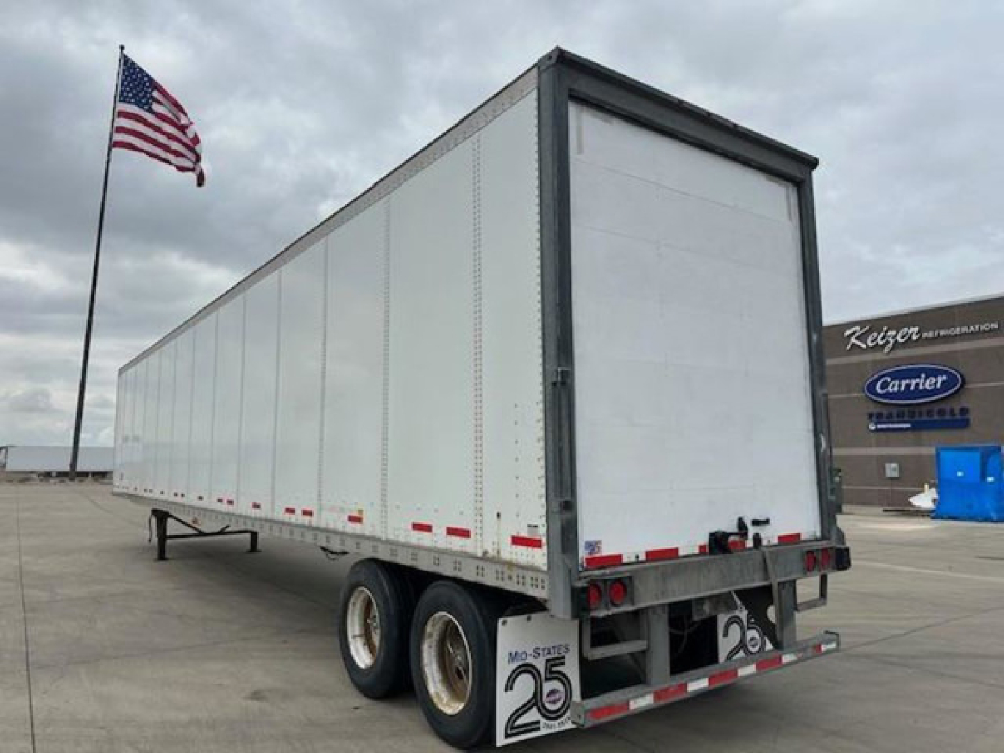 Trailer showing a long white dry van trailer with dual rear doors and tandem axles.
