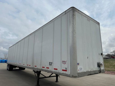 Trailer side view showing a white Wabash van trailer with riveted panels, 53' length markings, and rear undercarriage support legs.