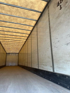 Interior of a Wabash trailer with ribbed ceiling and sidewall panels. Visible text on the side shows numbers '40' and 'Y' near the front.