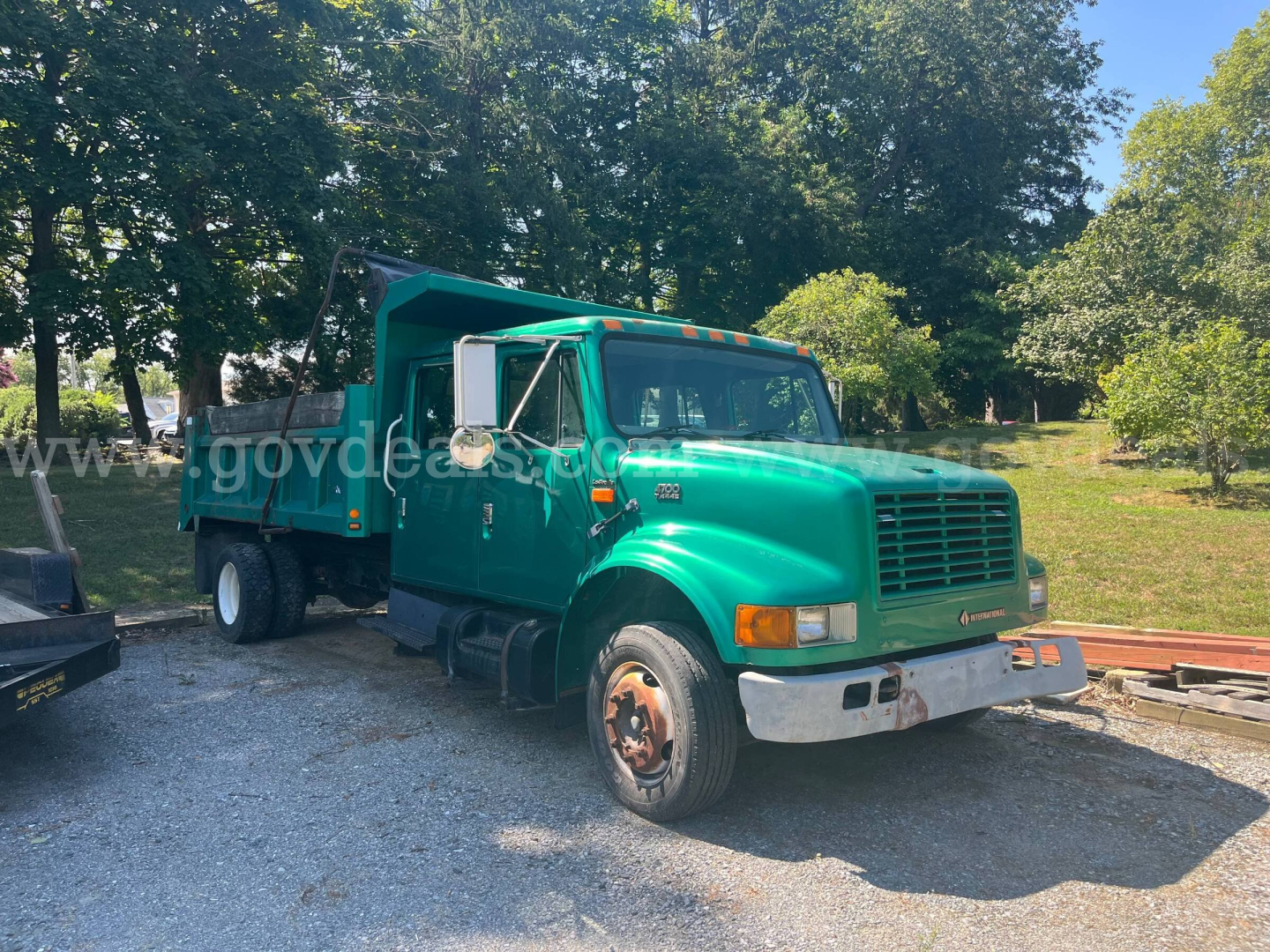 2002 International 4700 dump truck in green showing side and front, VIN tag and stock number not visible on image