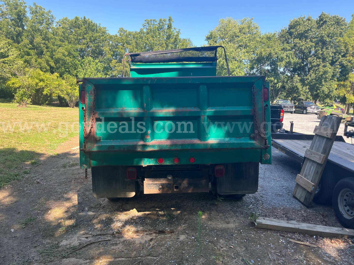 Dump truck bed of a 2002 International 4700 rear view showing green dump body and tailgate.