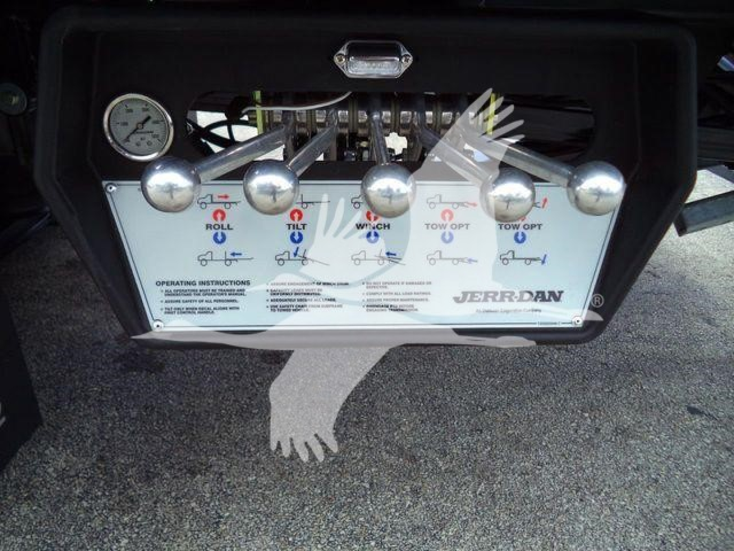 Dashboard panel with multiple control levers for a Jerr-Dan rollback truck, including labeled levers and a gauge.