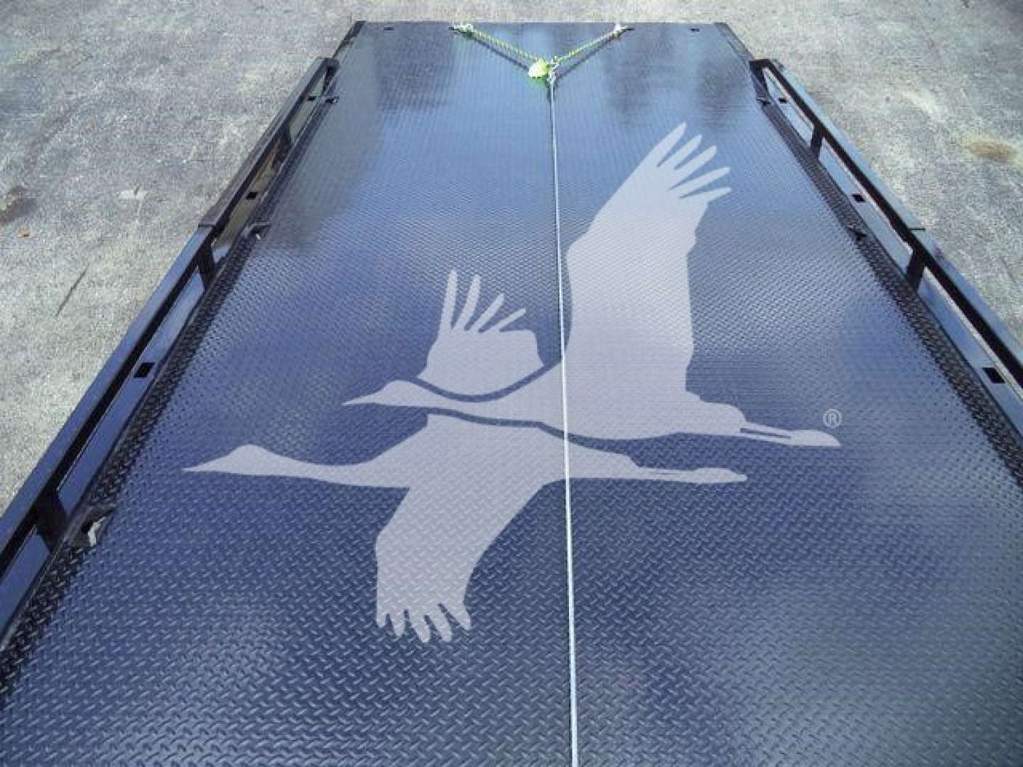 Flatbed truck deck with a large graphic of two birds in flight and a central seam; no legible text visible.
