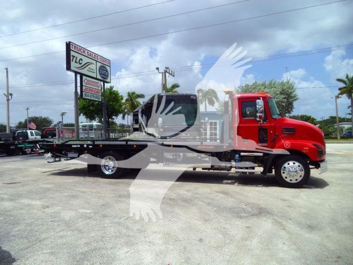 Mack MD6 rollback truck with flatbed in red cab and black frame, side view.