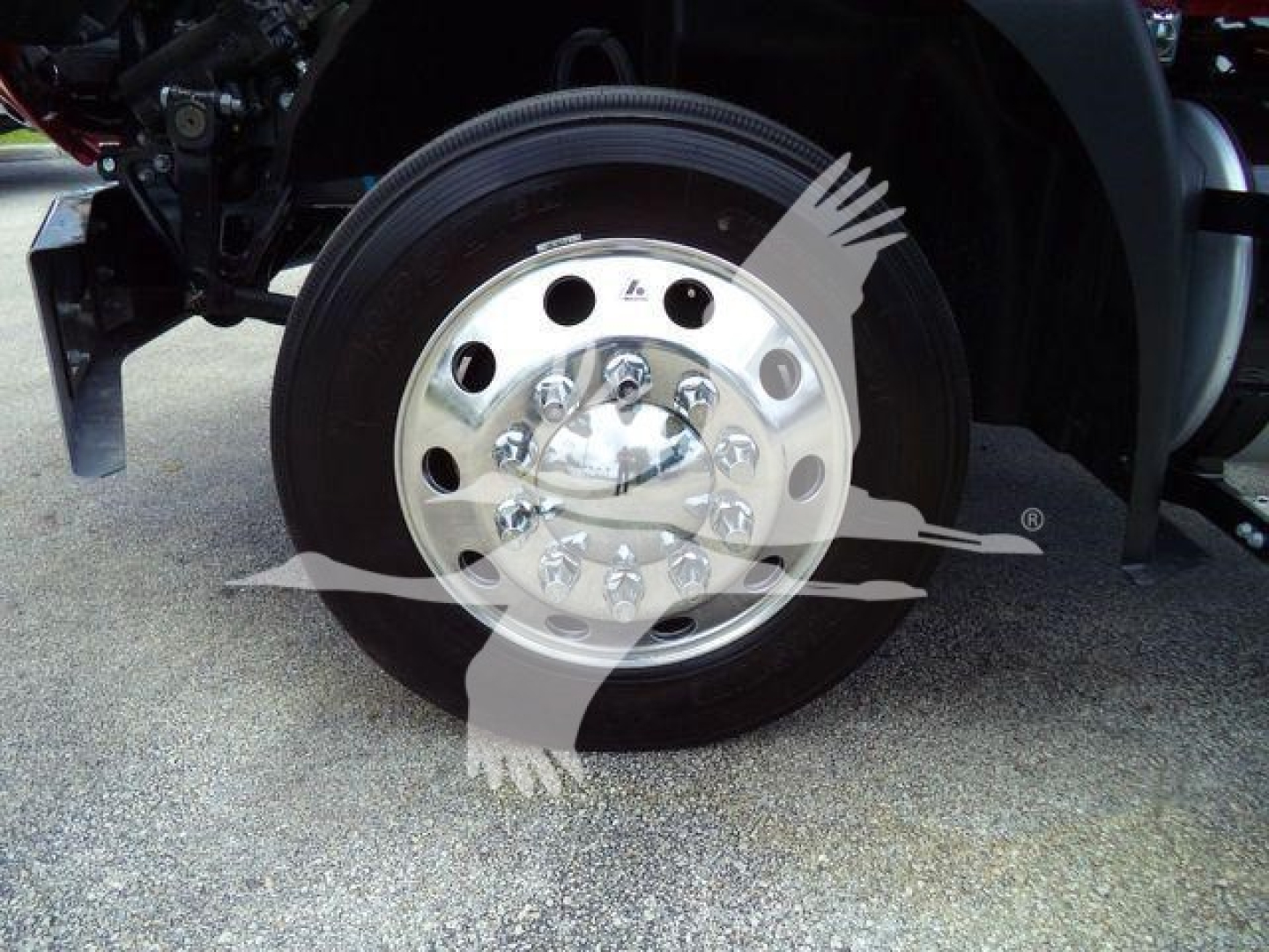 Mack MD6 truck front wheel showing polished aluminum hub and black tire, part of rollback truck chassis.