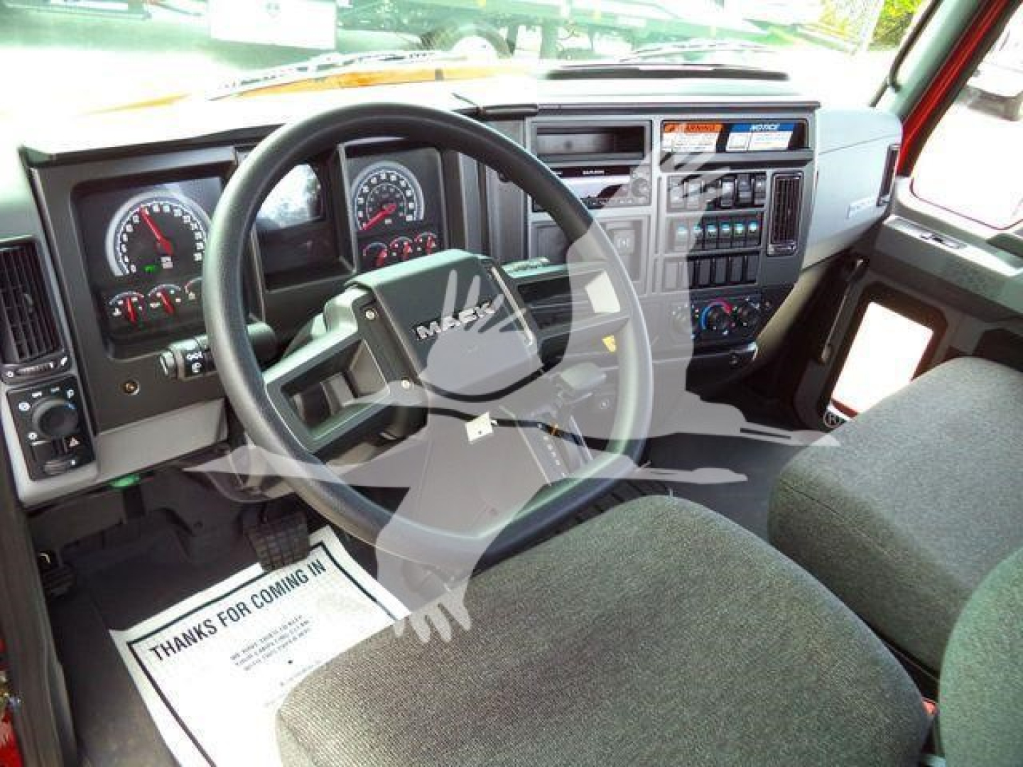 Mack MD6 truck interior showing steering wheel, dashboard gauges, center console, and driver seat from the cab interior.