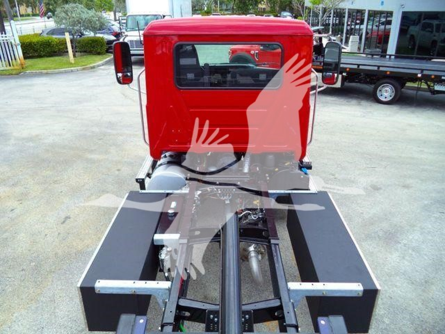 Red Mack MD6 truck cab rear view with rollback equipment in foreground and chassis visible.