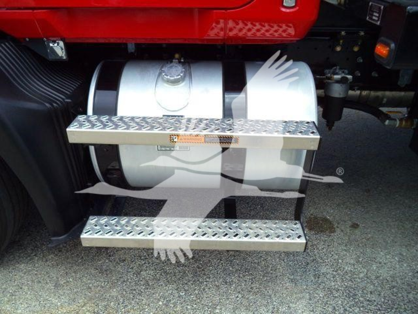 Truck side step with fuel tank on Mack MD6 engine bay showing diamond-plate steps and cylindrical tank.
