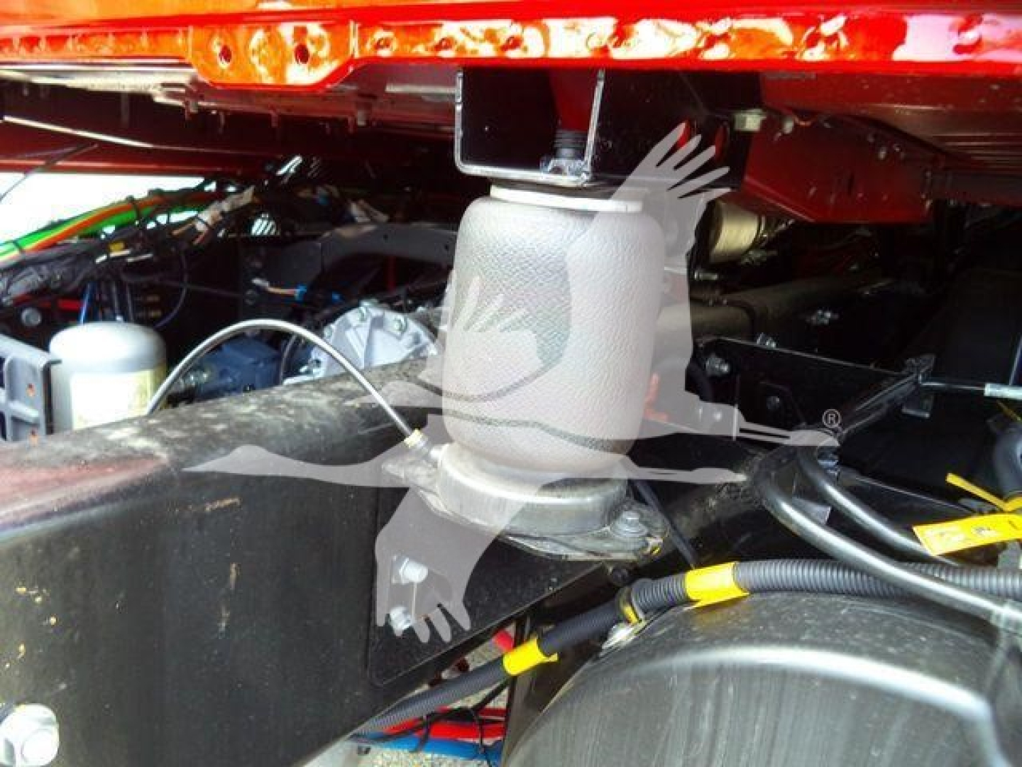 MD6 truck chassis component showing mounting bracket and hydraulic line connections under the cab