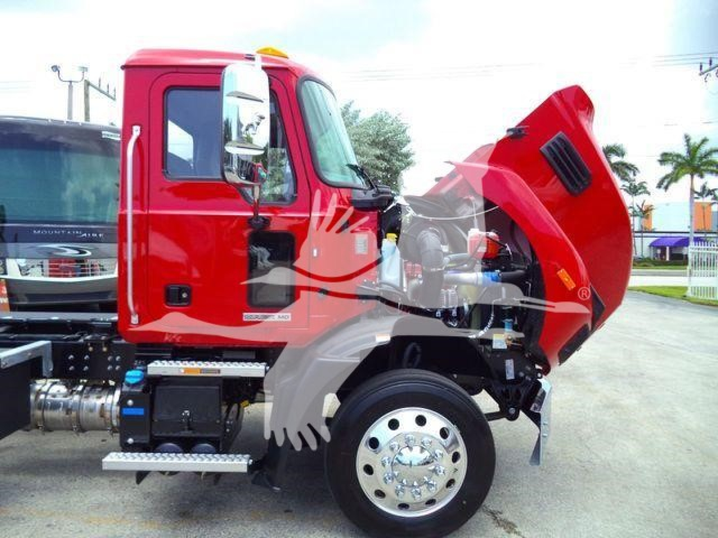 Red Mack MD6 truck cab with its hood open showing engine bay and front tires.