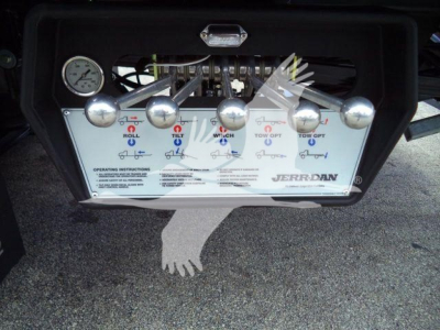 Dashboard panel with multiple control levers for a Jerr-Dan rollback truck, including labeled levers and a gauge.