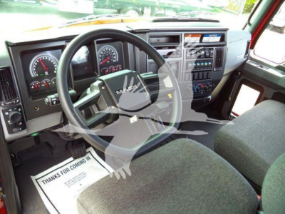 Mack MD6 truck interior showing steering wheel, dashboard gauges, center console, and driver seat from the cab interior.