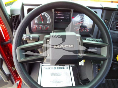 Steering wheel and dashboard interior of a 2026 Mack MD6 truck showing Mack-branded air bag cover and instrument cluster.