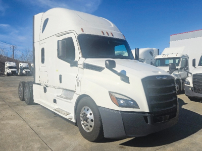 Freightliner Cascadia126 semi truck in a yard showing white cab and front grille with large mirrors.