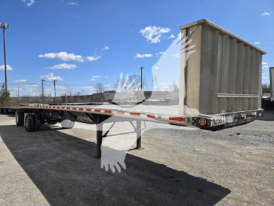 Flatbed trailer showing Fontaine Infinity with rear end ramp up and tandem axles visible.