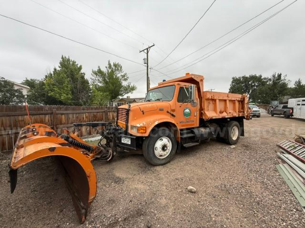 International 4900 truck with attached snow plow blade in front, orange dump bed, side view shows Vin: 1HTSDAAR4RH593721.