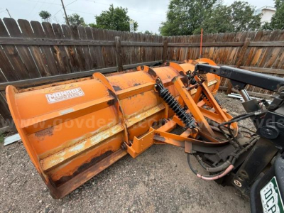 Snow plow blade attachment on a 1994 International 4900 truck with hydraulic linkage and orange paint.