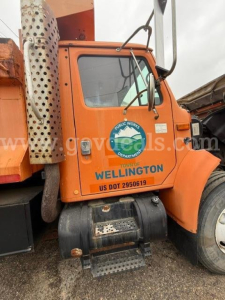 Truck cab side showing Wellington Public Works Department logo and US DOT on orange 1994 International 4900 plow truck.