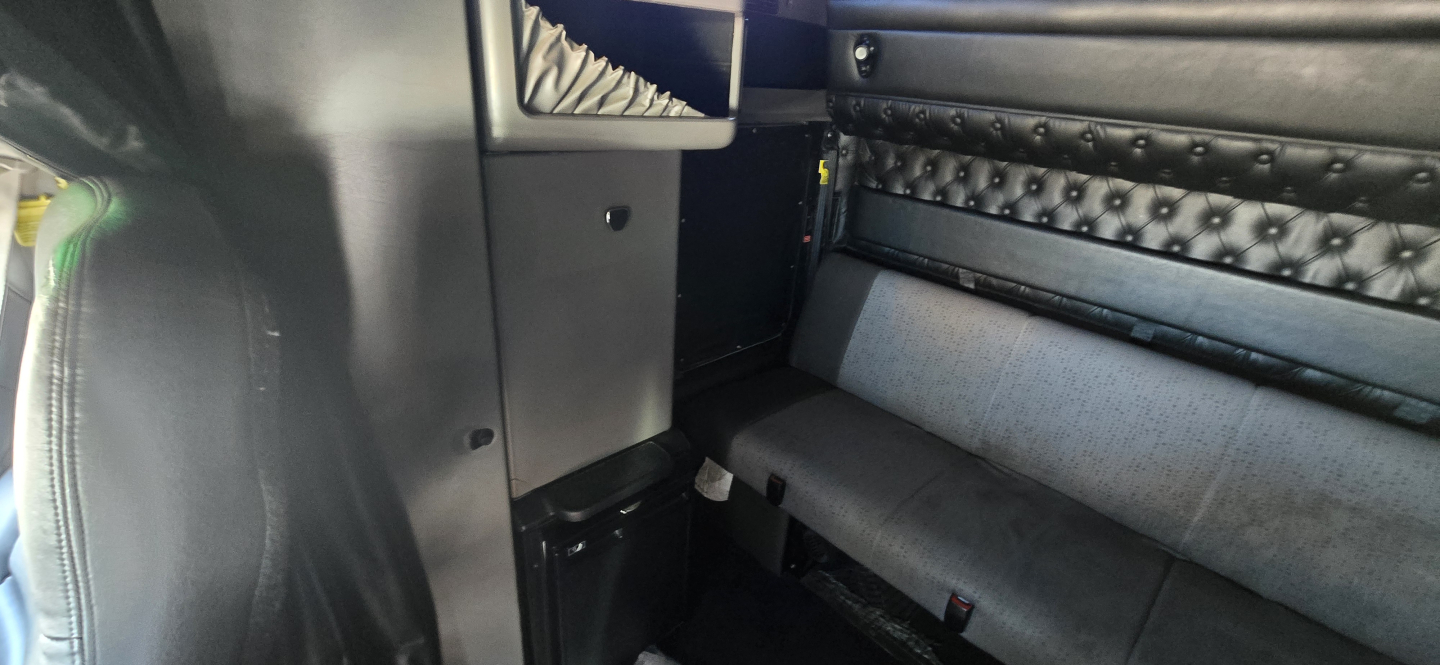 Kenworth W900 interior showing sleeper area with quilted door panel and bench seating