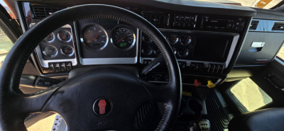 Kenworth W900 truck interior dashboard and steering wheel with gauges and controls visible.