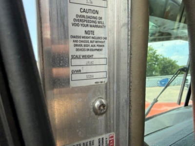 Kenworth W900 truck cab door sticker with GVWR and scale weight, view through door frame.