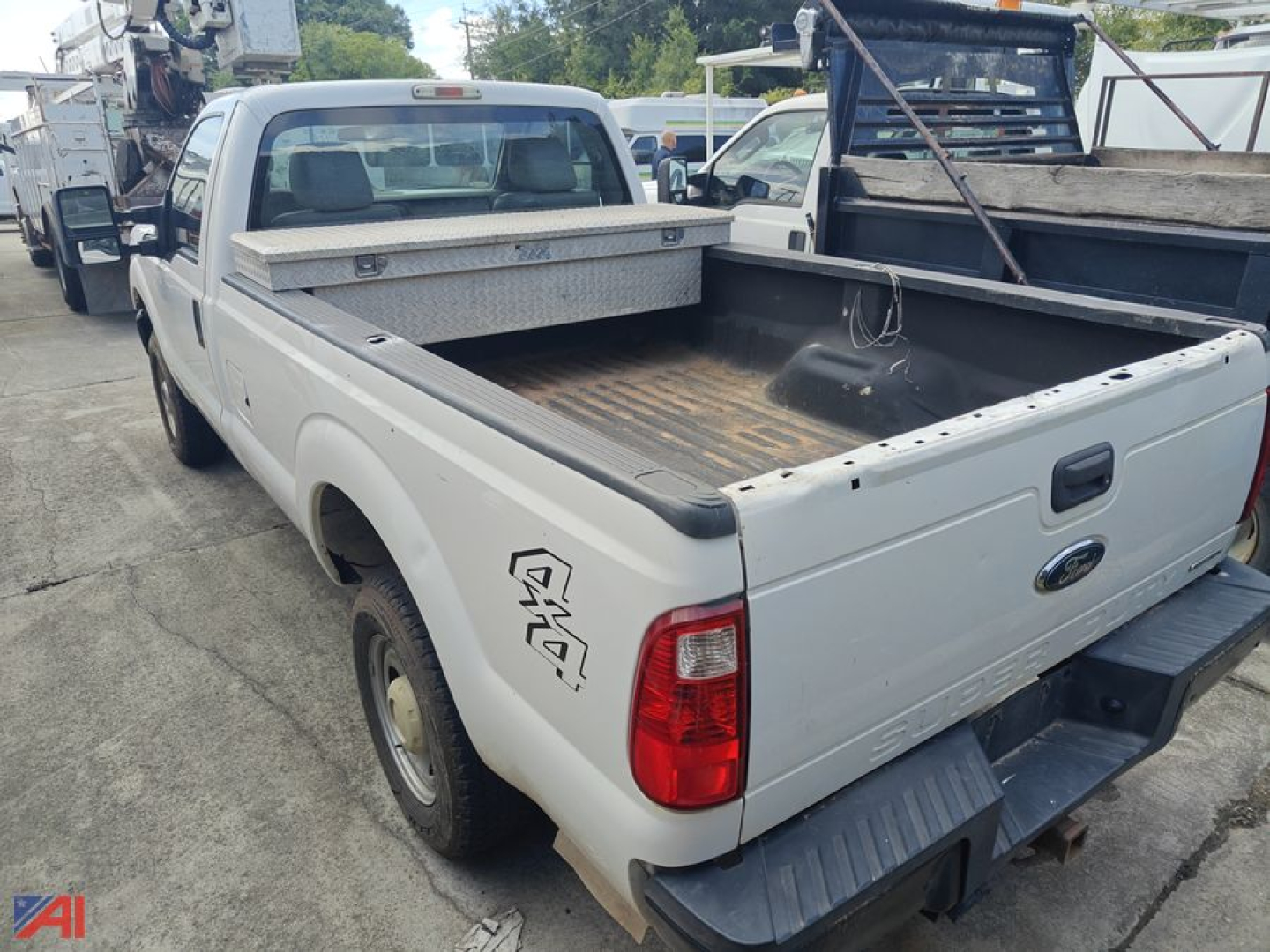 Ford F-250 pickup truck 2016 model rear and bed area showing alloy wheels, dual rear tail lights, and empty pickup bed with a side toolbox and hitch.