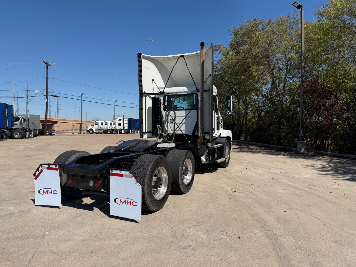 2023 Mack Anthem 64T tractor in a yard, rear view with mud flaps labeled MHC.