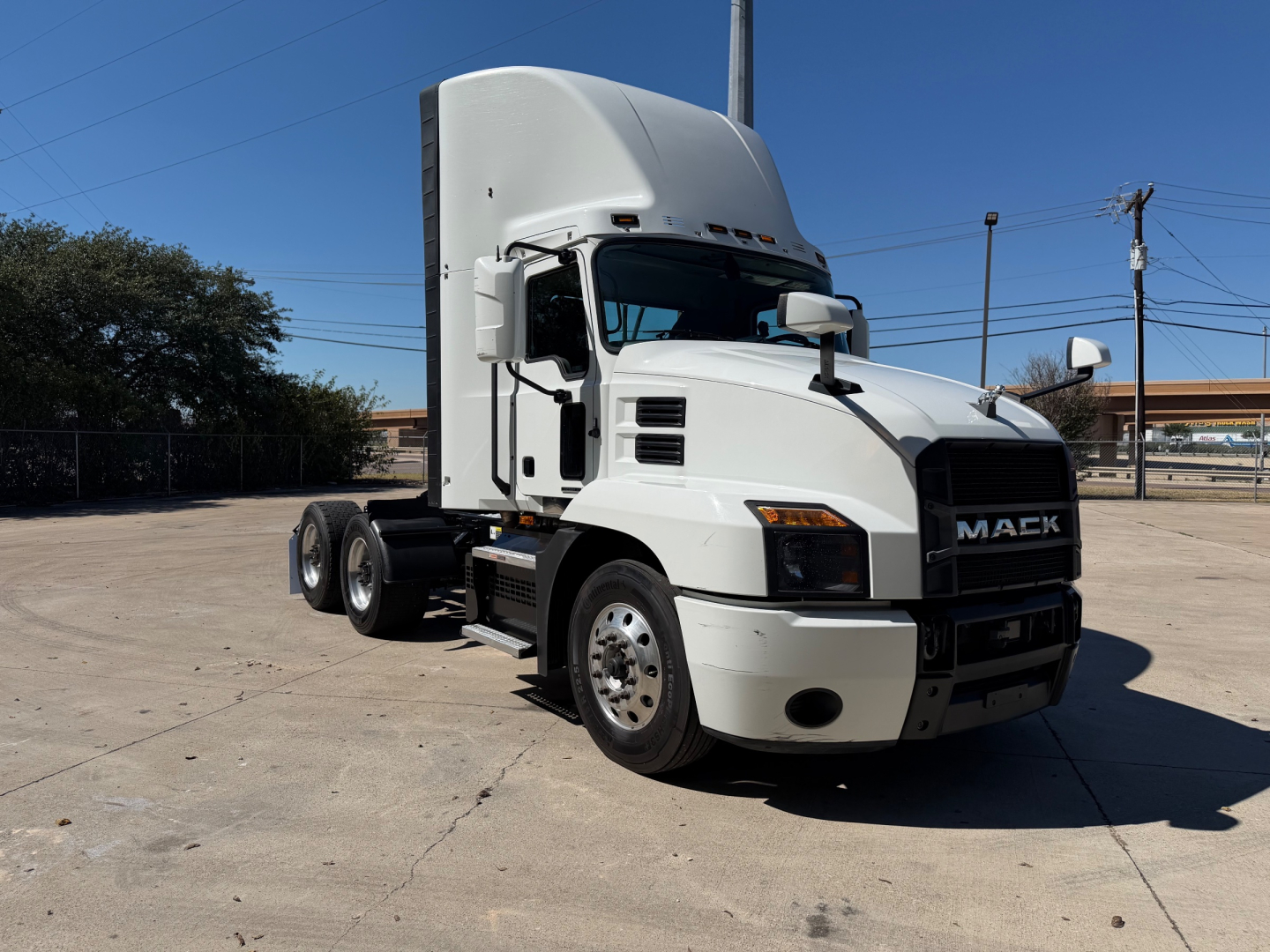 Mack ANTHEM 64T conventional daycab tractor showing front and side view with white paint and black grille.