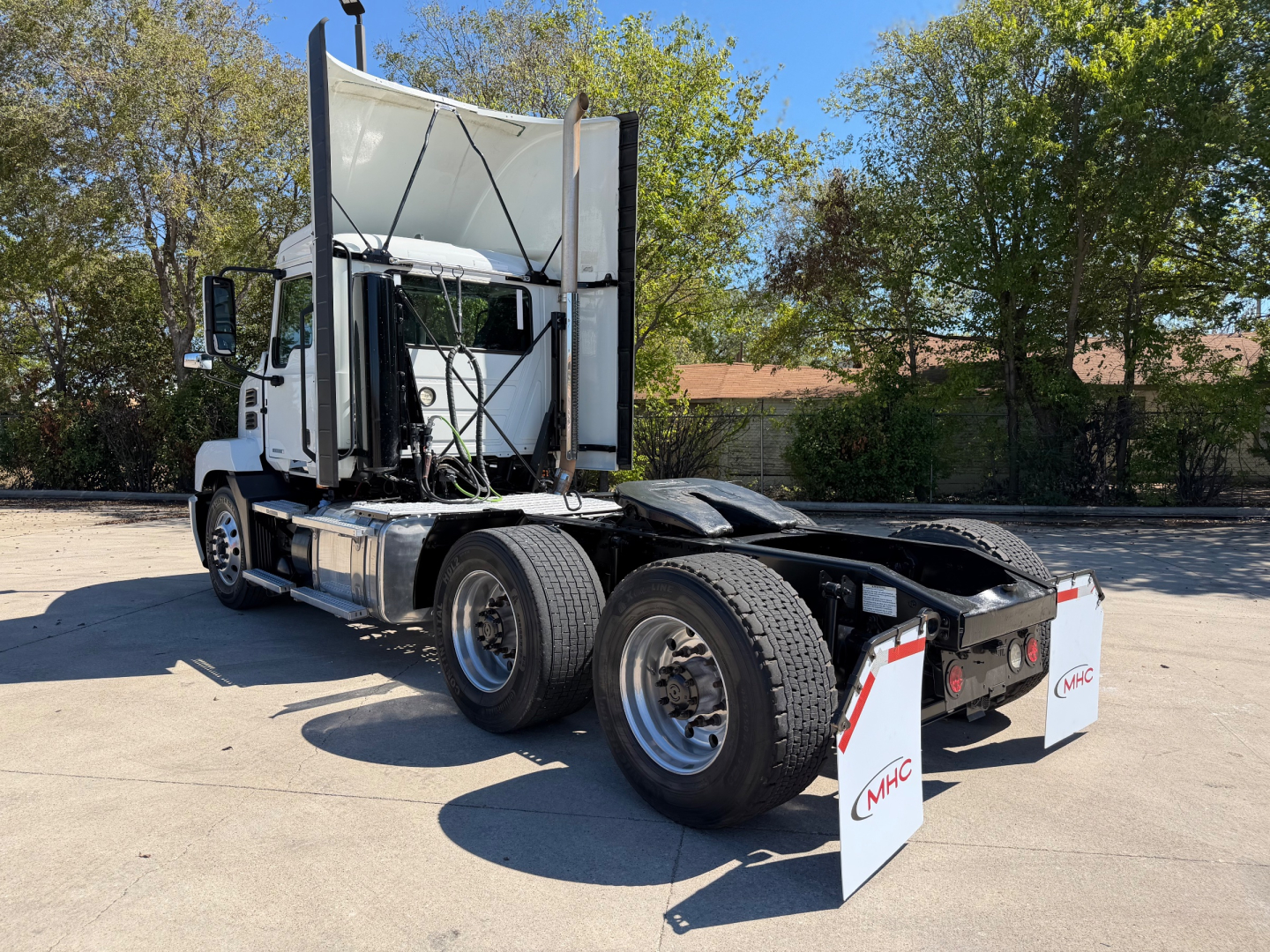 Truck tractor in a parking lot showing rear view with dual rear axles and sleeper cab. No visible text.
