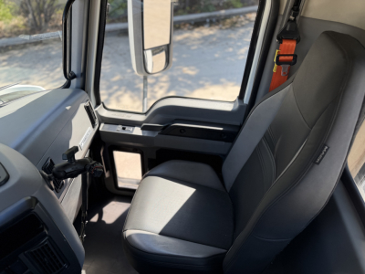 Cab interior of a 2023 Mack ANTHEM 64T semi-truck showing driver seat and dashboard with window view.