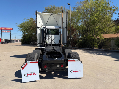 Tractor-trailer rear view showing cargo area and mud flaps with MHC logo and dual rear tires.