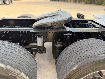 Tractor-trailer cab view showing fifth-wheel mounting and dual rear axles with dual tires for a 2023 Mack ANTHEM 64T, undercarriage components visible.