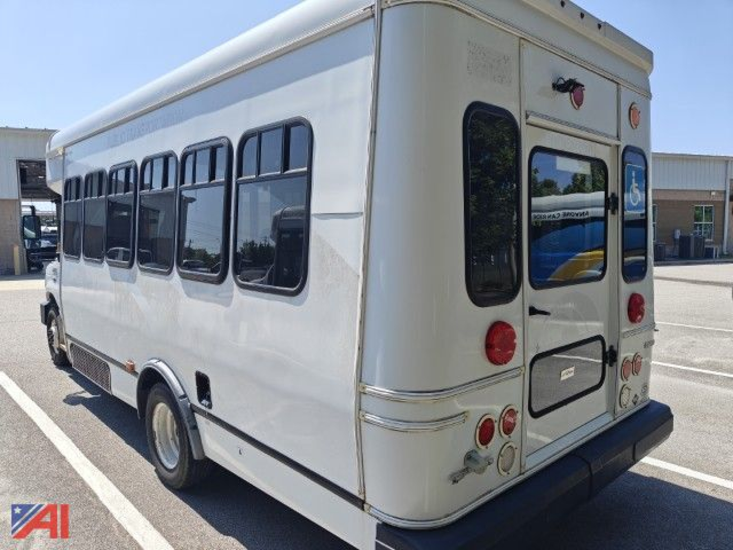 Ford E350 wheelchair bus rear-right view showing wheelchair accessibility stickers and side windows.