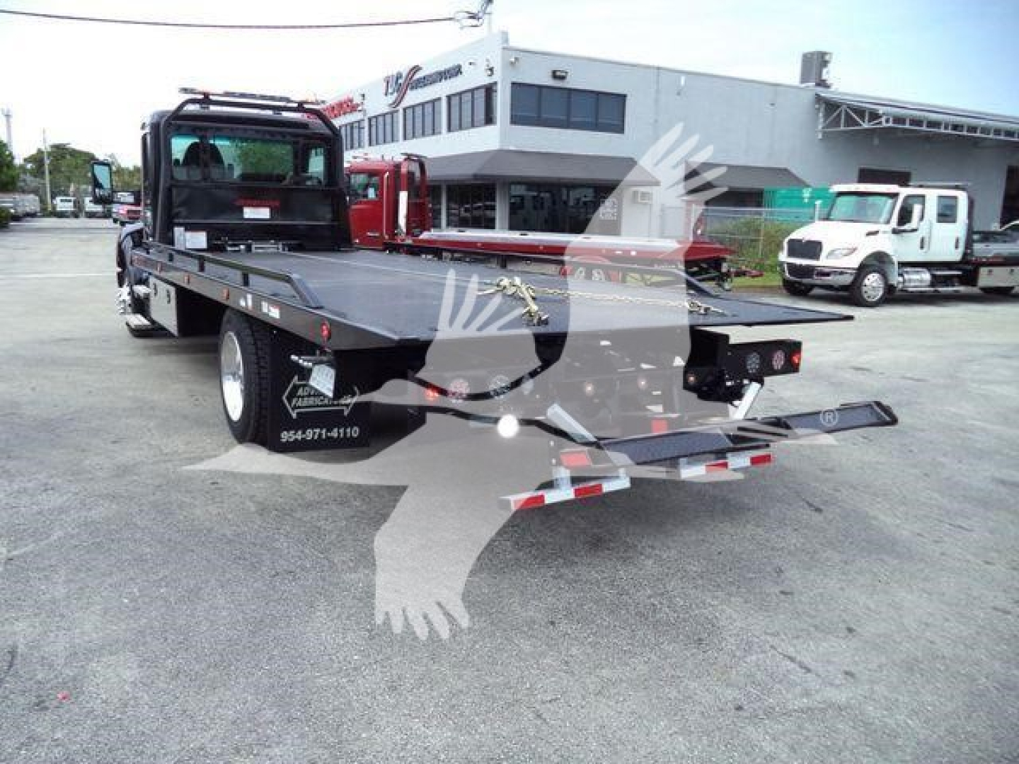 Kenworth T280 rollback flatbed tow truck rear view showing loading ramps and hydraulic system